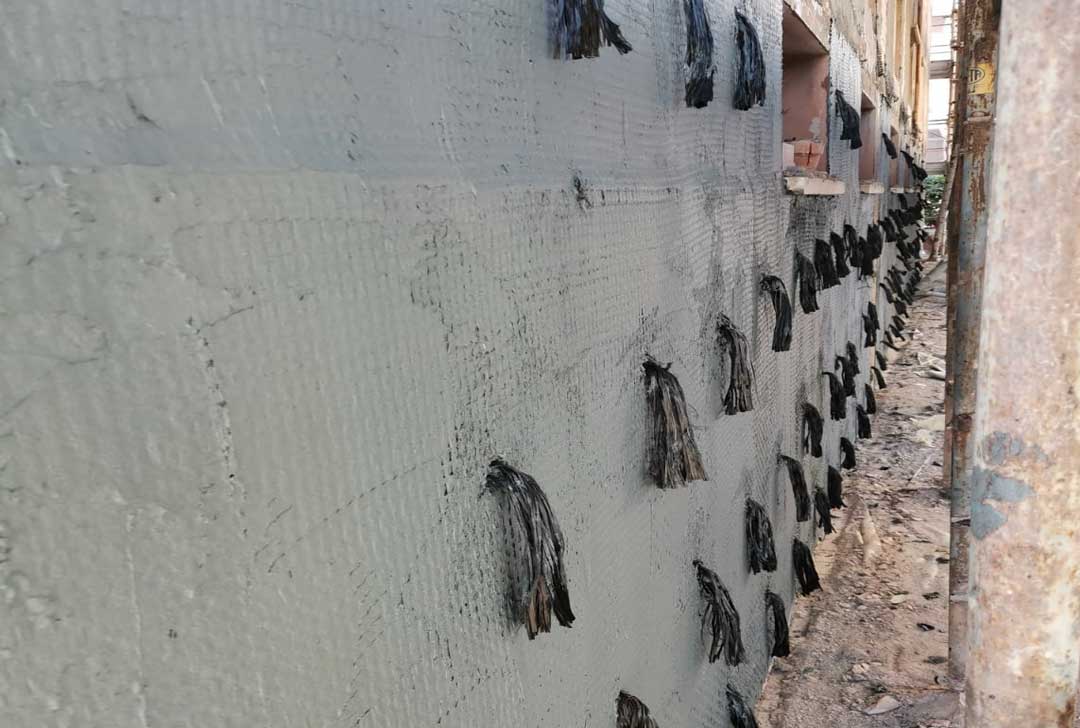 Reinforcement of main wall bays by laying pultruded bars and carbon fiber fabrics with associated carbon flake connections